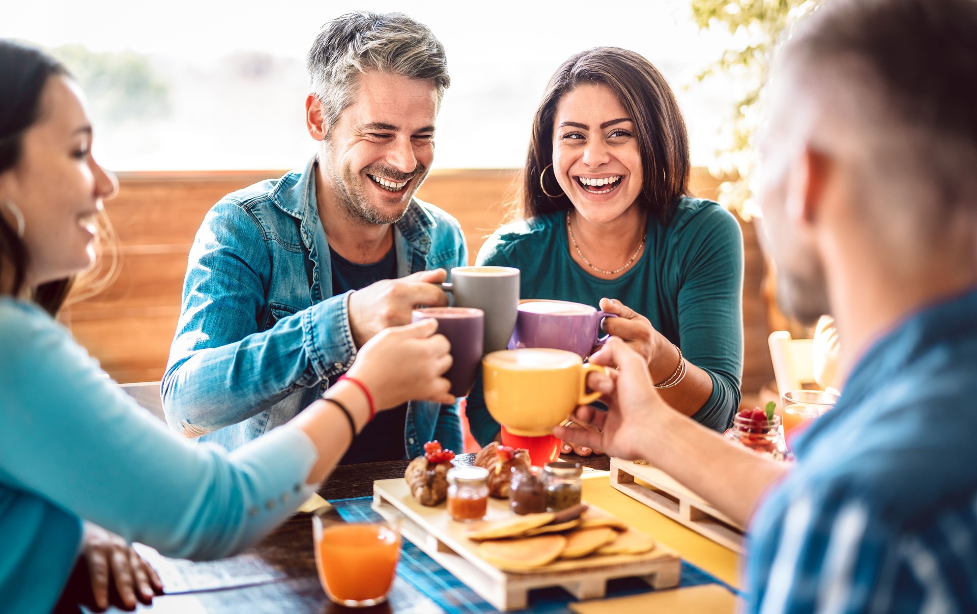 People group toasting latte at coffee bar rooftop - Friends talking and having fun together at cappuccino restaurant - Life style concept with happy men and women at cafe terrace - Bright warm filter